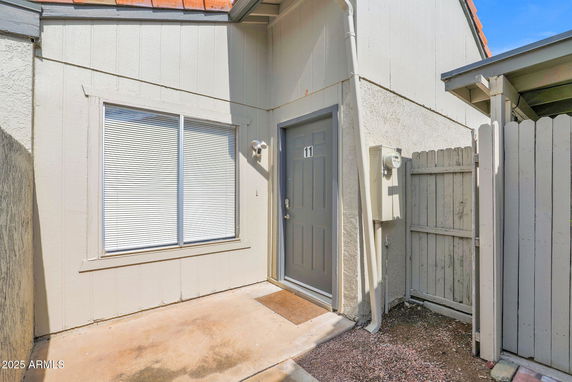 Front view of a house with a door labeled number 11 and a window with blinds.