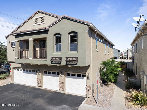 Front view of a two-story house with three garages.