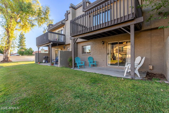 Rear view of a two-story building with balconies and patio area.