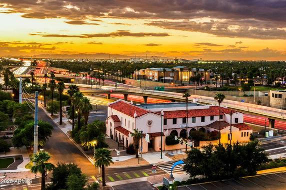 Panoramic view of a building near a busy highway at sunset.