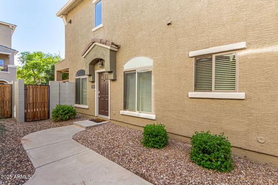 Front view of a two-story house with a brown door and arched windows.
