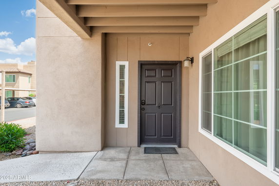 Front view of a house entrance with a black door and windows.