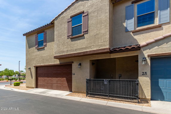 Front view of a two-story house with a brown garage door and window shutters.