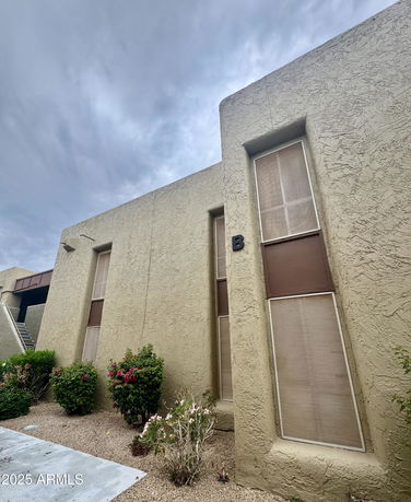 Front view of a textured building with tall narrow windows.