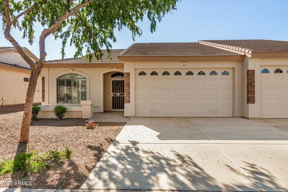 Front view of a single-story house with a garage and arched window.