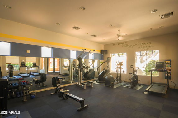 Indoor gym area with exercise equipment and large mirrors on the wall.