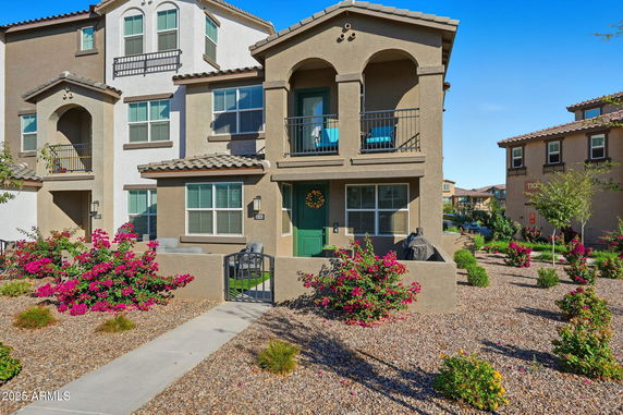 Front view of a multi-story house with balconies and a green entrance door.