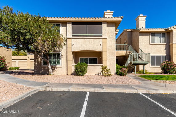 Front view of a two-story building with a staircase and balconies.