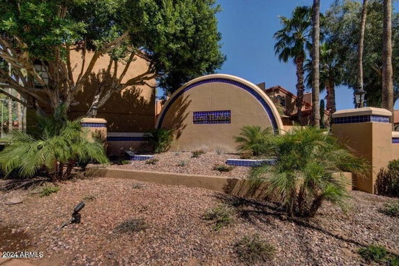 Front view of a building with a curved decorative wall and tile accents.