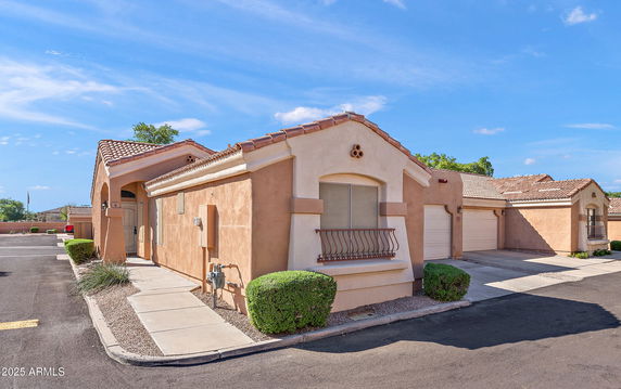 Front view of a single-story house with a flat path and arched entryway.