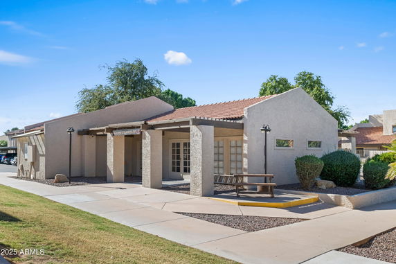 Front view of a single-story building with a red-tiled roof and beige exterior.