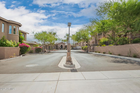 Front view of residential buildings with a gated entrance and landscaped area.