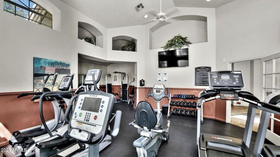 Interior view of a gym with exercise equipment and a high ceiling.