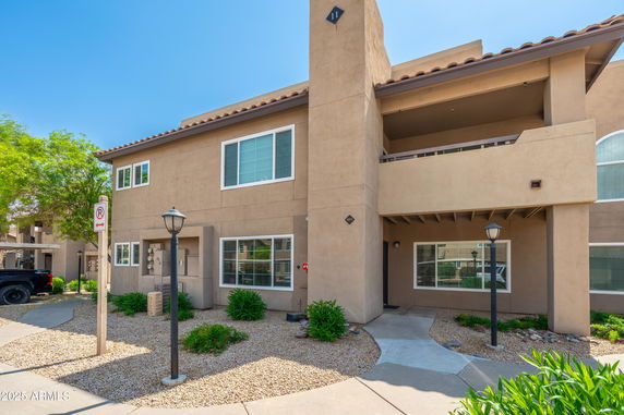 Front view of a two-story residential building with large windows and a small porch.