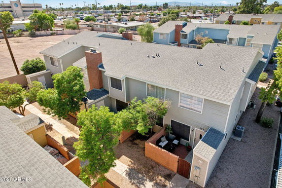 Aerial view of a residential complex with multiple two-story houses featuring grey roofs and brick chimneys.