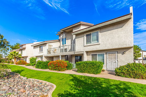 Front view of a two-story building with balconies and large windows.
