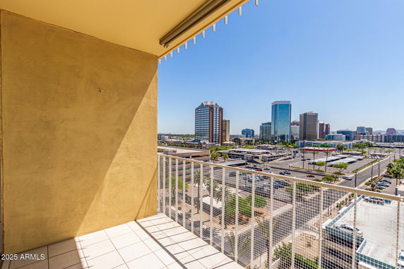 View of cityscape from a balcony with tall buildings visible in the distance.