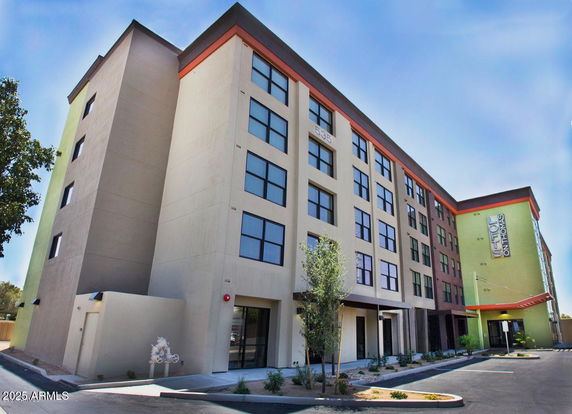 Front view of a multi-story building with large windows and a modern design.