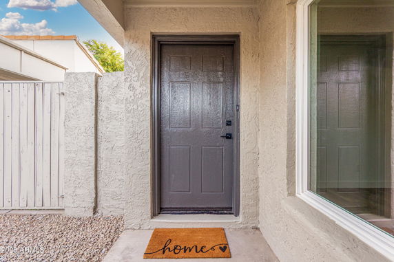 Front entrance of a house with a gray door and a welcome mat.
