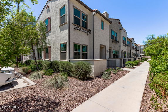 Front view of a row of modern townhouses with landscaped surroundings.