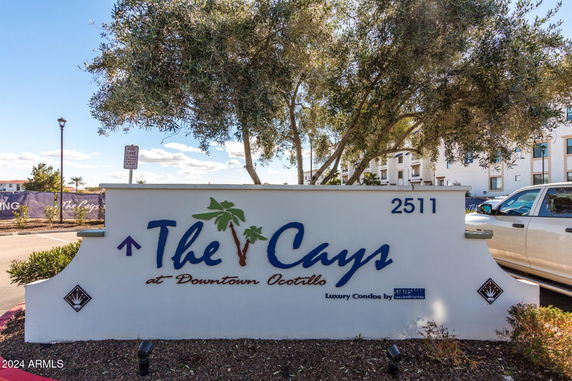 Front view of a luxury condo development with a sign reading 'The Cays at Downtown Ocotillo'.