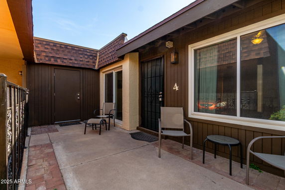 Front view of a house with a small patio and brown exterior.