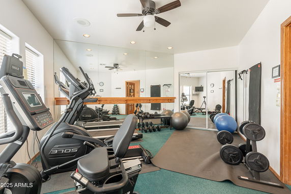 Home gym area with exercise equipment and mirrored wall.