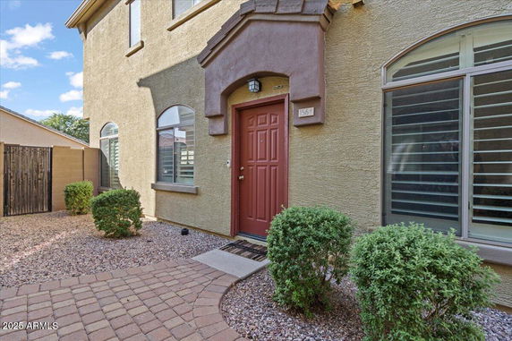 Front view of a house with a red door and arched windows.