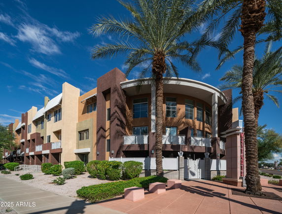 Front view of a modern multi-story building with a curved section and angular design elements.