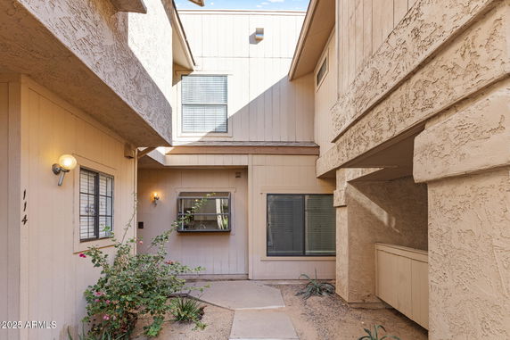 Front view of a house with a beige exterior and multiple windows.