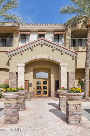 Front view of a multi-story building with an arched entrance and decorative stone columns.