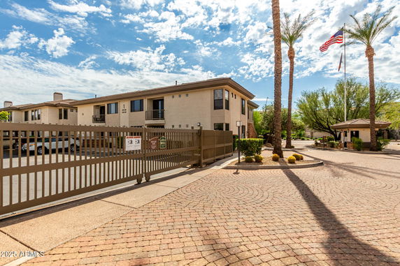 Front view of a multi-story building with a gated entrance.