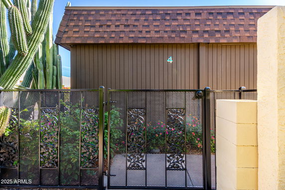 Front view of a building with a decorative metal gate and a brown shingle roof.