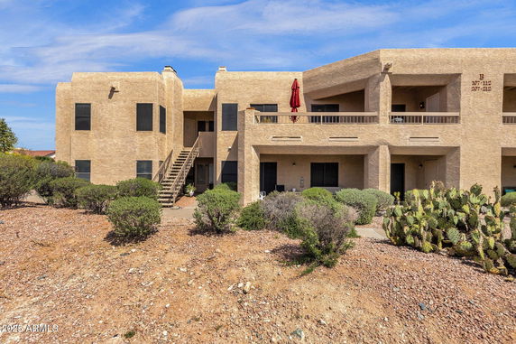 Front view of a two-story building with a staircase and balconies.
