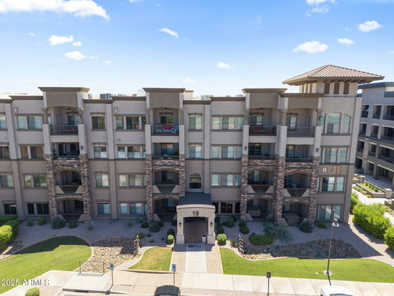 Front view of a multi-story apartment building with balconies and stone accents.