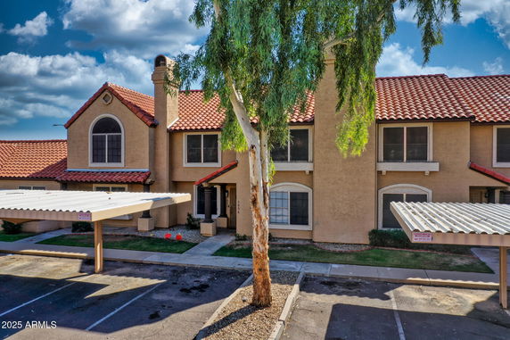 Front view of a house with a red-tiled roof and two stories.
