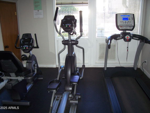 Indoor gym area with exercise equipment including a treadmill and elliptical machines.