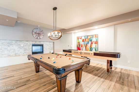 Indoor recreation room with a pool table and shuffleboard table.