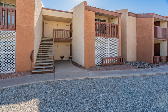 Front view of a two-story building with external staircases and balconies.