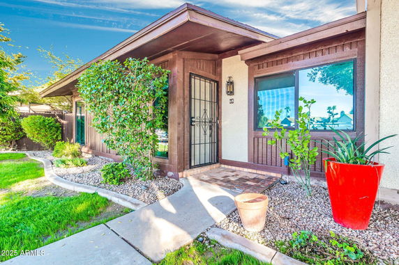 Front view of a house with wooden accents and a covered entryway.