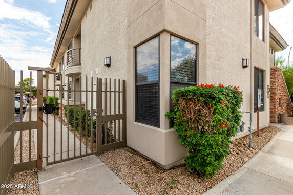 Corner view of a modern two-story building with a small gated entrance.