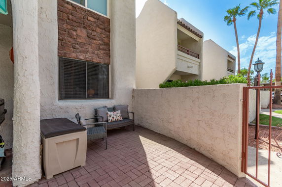 Front view of a multi-story building with a patio area and brick accents.