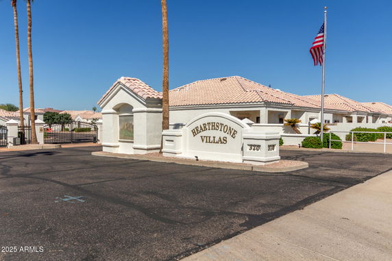 Front view of a building complex with a gated entrance and sign for Hearthstone Villas.