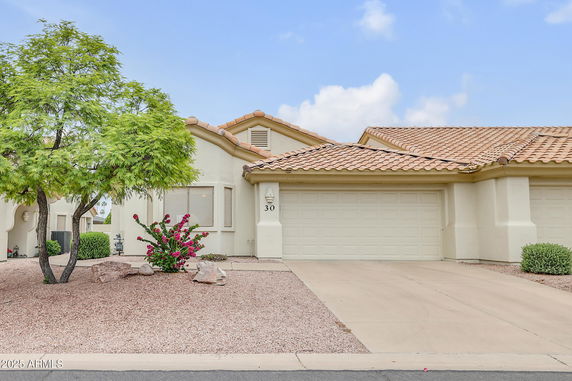 Front view of a house with a two-car garage and a tiled roof.