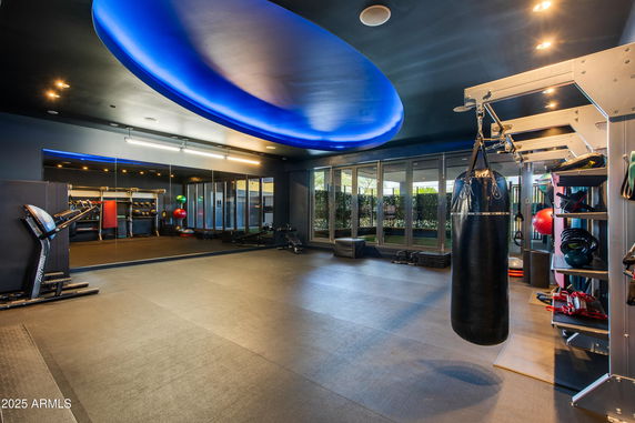 Interior of a gym with exercise equipment and a punching bag.