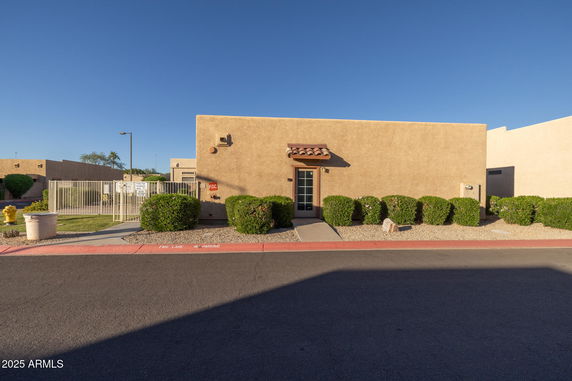 Front view of a single-story building with beige exterior and a wooden door.