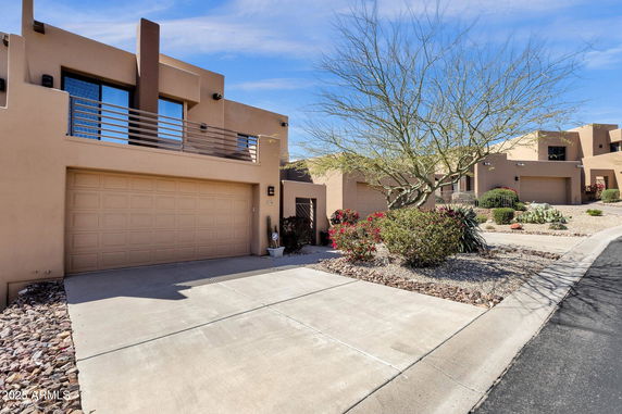 Front view of a modern two-story house with a balcony and double garage.