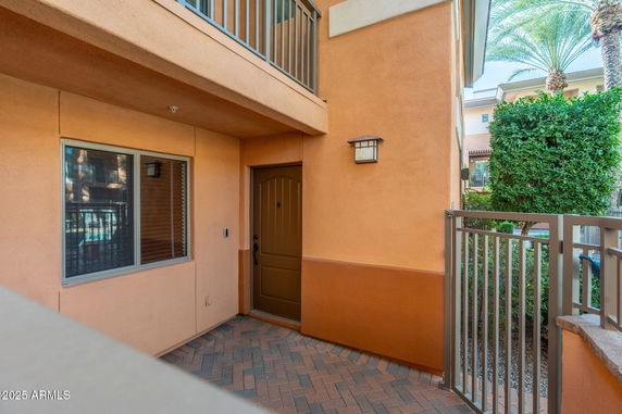 Exterior view of a building entrance with a brown door and adjacent window.