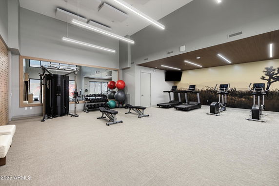 Indoor gym area with exercise equipment like treadmills, exercise bikes, and weight machines.