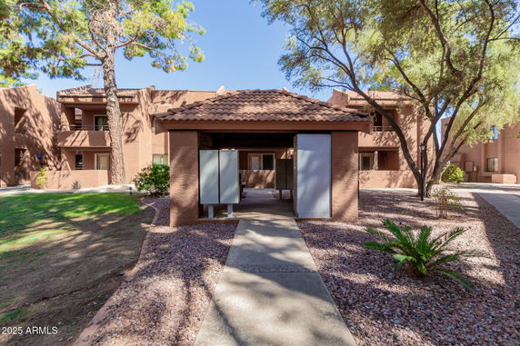 Front view of a two-story building with a tile roof and pathway leading to the entrance.